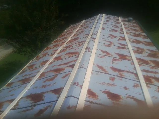 Rusted metal roof panels with new wood purlins before replacement — Storm Damage Roof Repair in Pewamo by Roofing Brothers